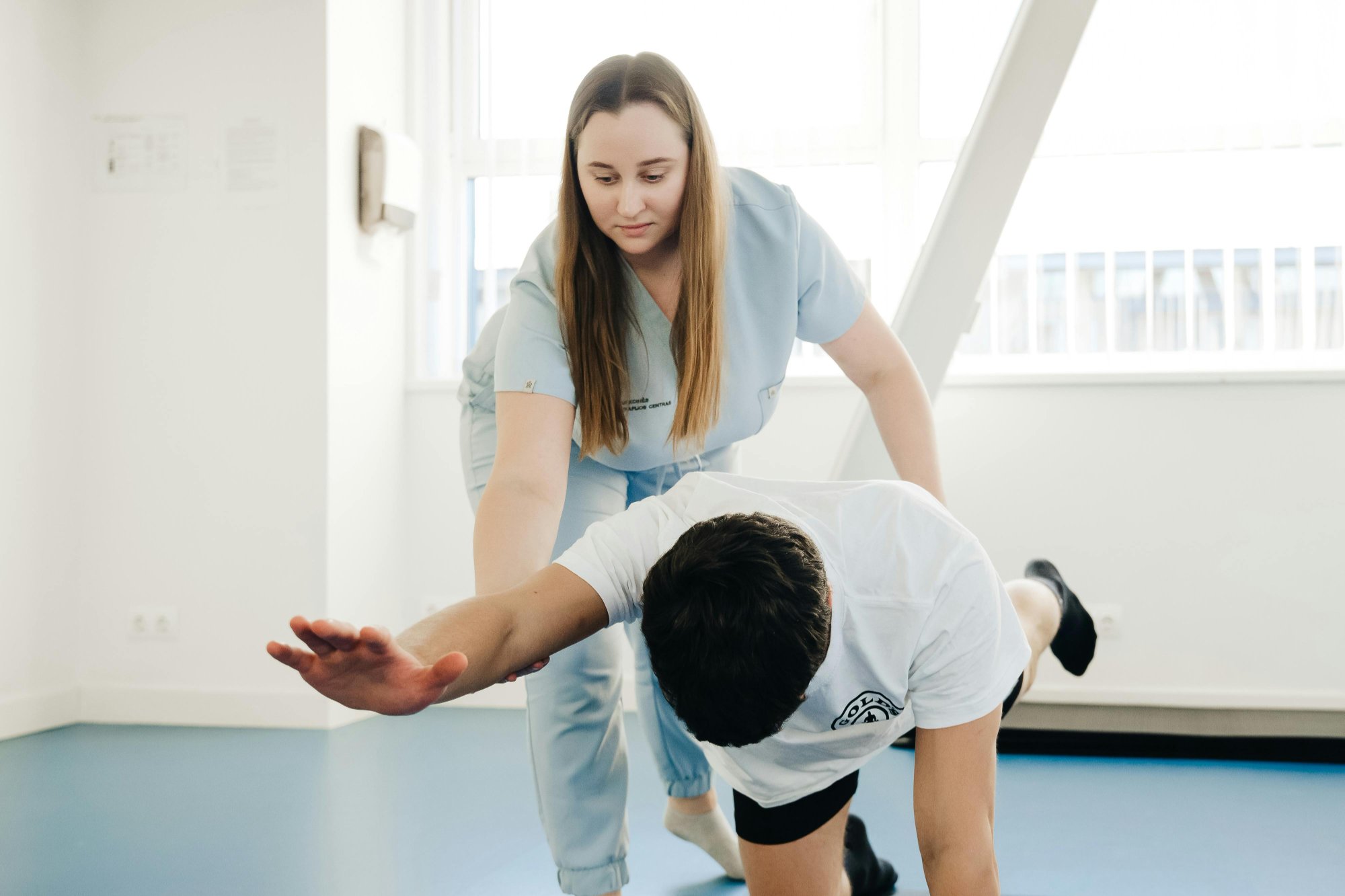 Physical therapy assistant helping patient with rehabilitation exercises
