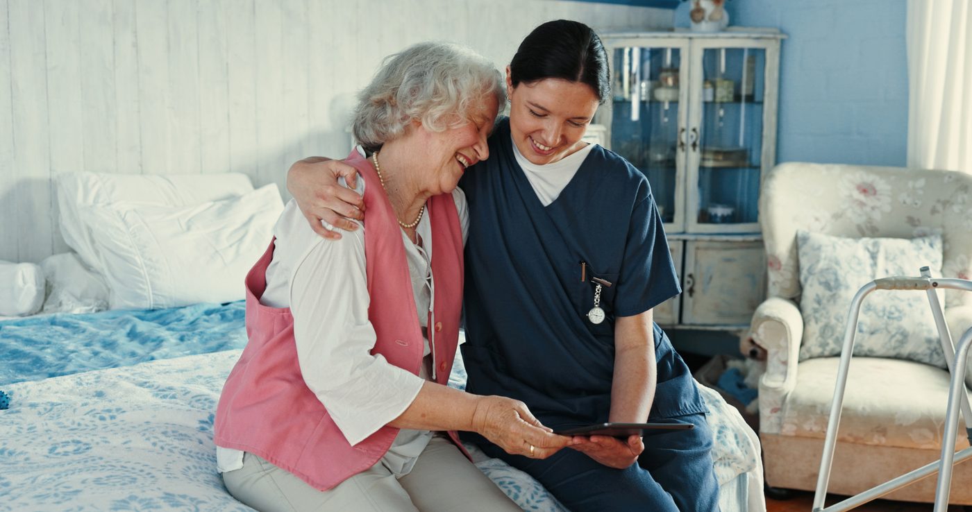 Home health aide assisting elderly patient at home