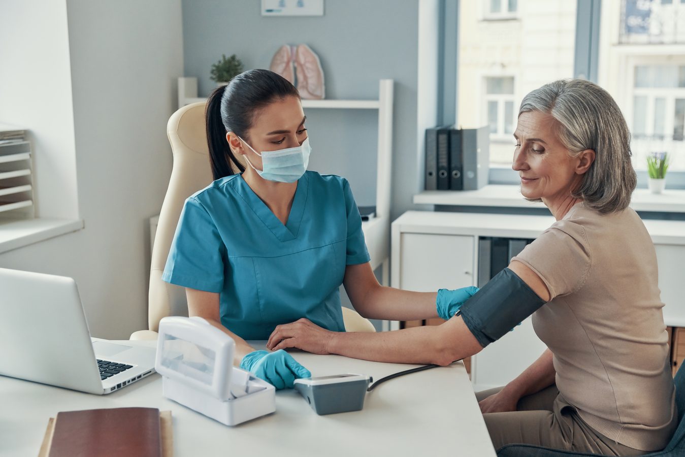 Medical assistant preparing patient for examination