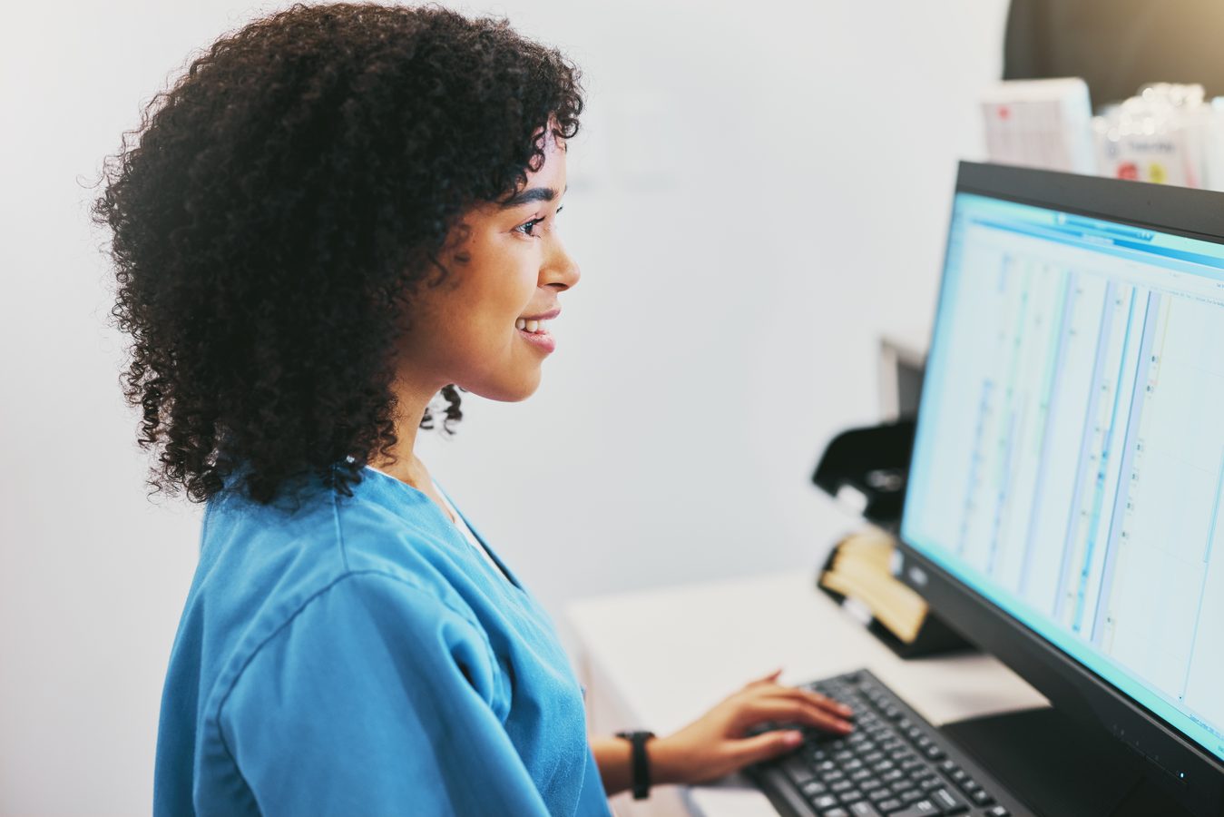 Medical coder reviewing patient records on computer