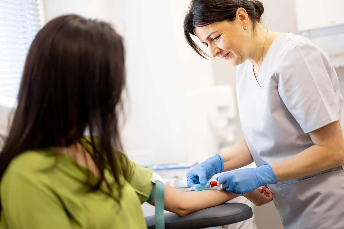 Phlebotomist drawing blood from patient